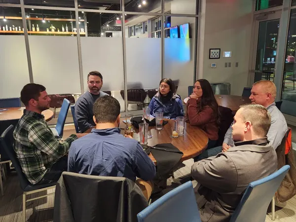 Members talking around a table at a meetup
