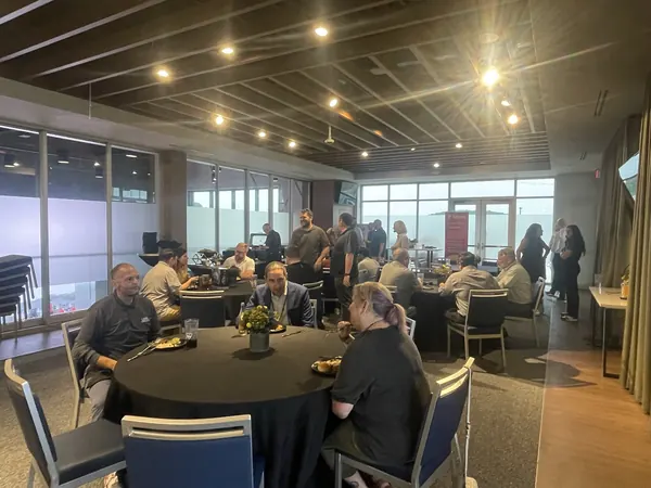Wide view of a dinner meeting with members seated at round tables