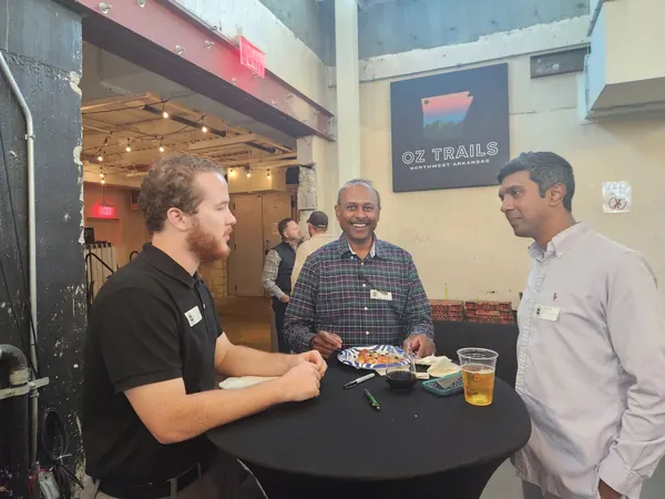 Three members talking at a high-top table