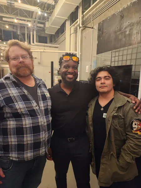 Three members posing together at an evening event